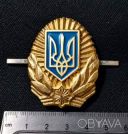 Кокарда з золотистим тризубом у синьому щиті